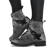 image shows lace up combat boots with a black sole and laces. Just above ankle length. The boots feature a print of swooping ravens in black on a gothic grunge grey background