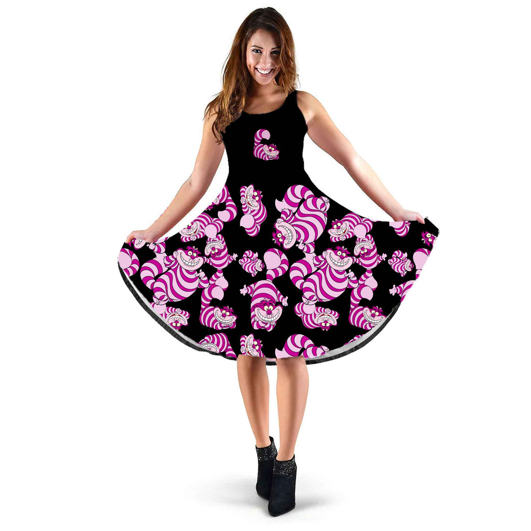 image shows a knee length sleeveless sundress in black with cheshire cats printed on the skirt part in pinks and purples.  The bodice of the dress is black with one cheshire cat on it.  