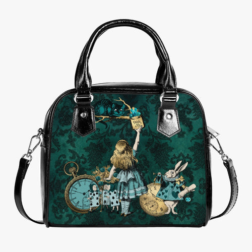 Alice in Wonderland bottle green handbag with alice and the cheshire cat. Alice and friends are in pastel green. Alice is reaching up for the 'drink me' bottle watched over by the cheshire cat. The background is a deep green damask print.