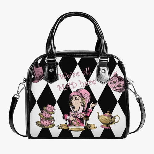 Mad hatter handbag featuring the mad hatter surrounded by teacups, teapots and top hats on a black and white diamond background. The bag has black handles and shoulder strap. With the quote 'we're all mad here'