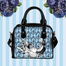 Load image into Gallery viewer, pastel blue alice in wonderland shoulder purse featuring alice and the white rabbit on a pale blue background.  the handbag has black handles and shoulder strap.  Approximate dimensions are 9 inches wide and 8 inches high.
