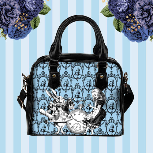 pastel blue alice in wonderland shoulder purse featuring alice and the white rabbit on a pale blue background.  the handbag has black handles and shoulder strap.  Approximate dimensions are 9 inches wide and 8 inches high.