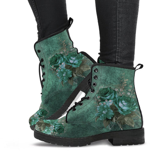 green gothic lace up combat boots. A darkish green grungy background with the green gothic roses print in the foreground. the boots are just above ankle length and have a black rubber sole.