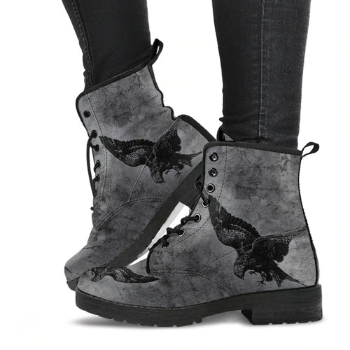 image shows lace up combat boots with a black sole and laces.  Just above ankle length.  The boots feature a print of swooping ravens in black on a gothic grunge grey background