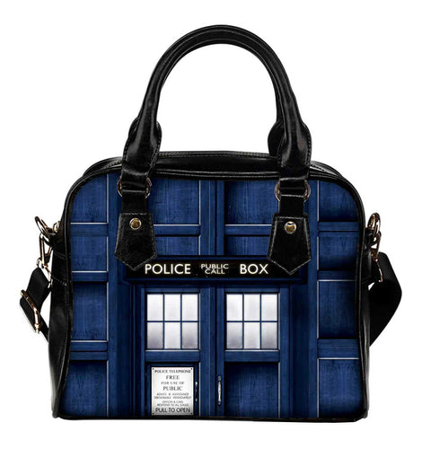 dr who police box shoulder handbag with black handles and an adjustable shoulder strap.  the bag is approximately 9 inches wide and 8 inches tall and features a closeup print of the outside of the tardis. 